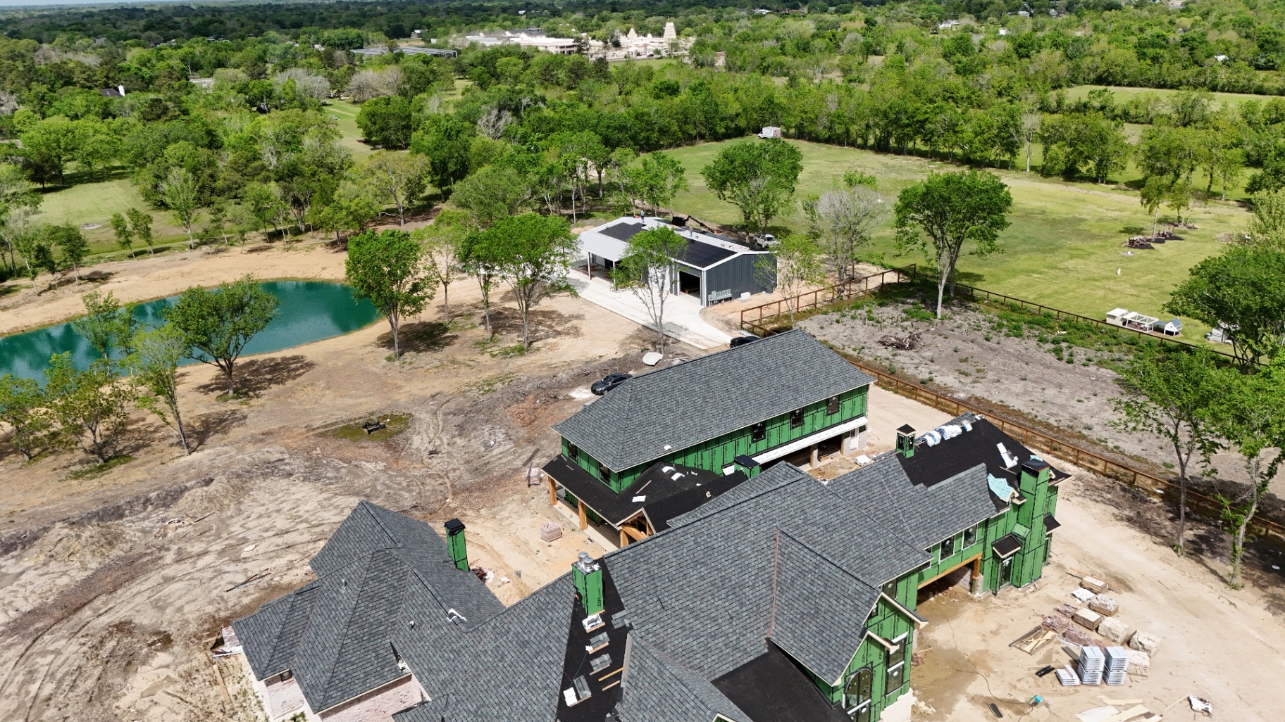 Site overview — barn-mounted array alongside the main 14,000 sq. ft. residence under construction.